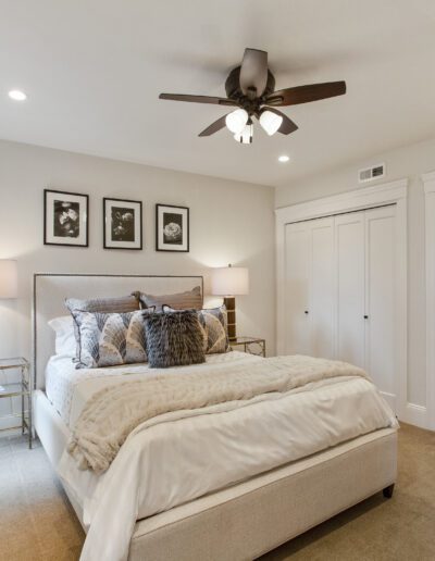 Elegant bedroom with a plush bed, ceiling fan, and neutral color palette.