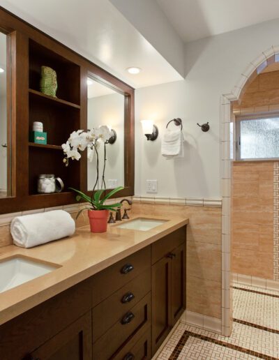 Spacious bathroom with double vanity, wood cabinetry, and a tiled walk-in shower.